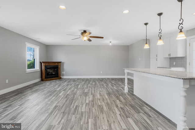 123 Somerset Rd, Stevensville, MD 21666 - unfurnished living room featuring a ceiling fan, baseboards, light wood-style flooring, recessed lighting, and a fireplace