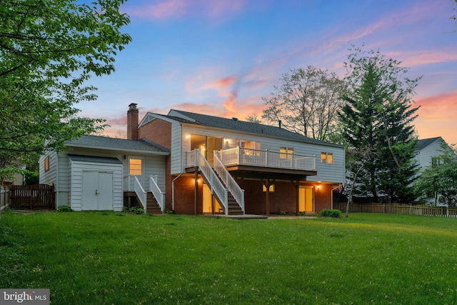 rear view of property with a yard, a fenced backyard, stairs, a chimney, and a deck