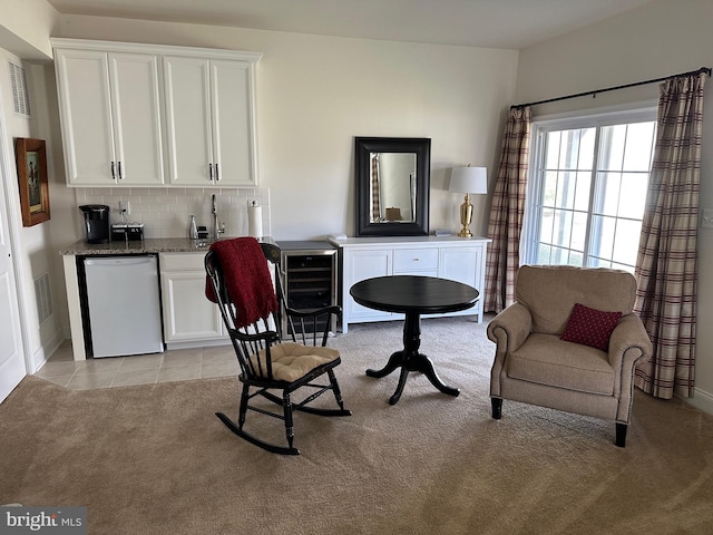 8537 Pine Springs Dr, Severn, MD 21144 - sitting room featuring wine cooler, indoor wet bar, light tile patterned floors, light colored carpet, and visible vents