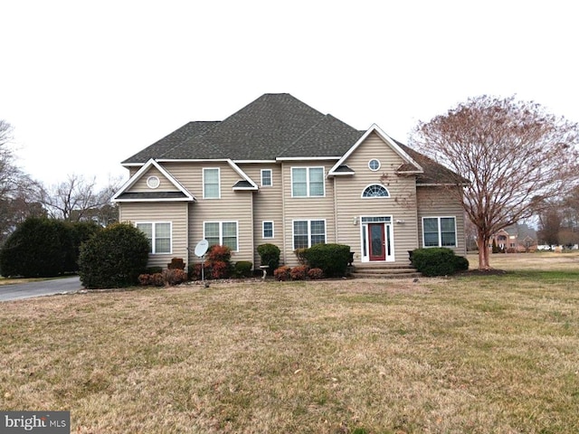 view of front facade featuring roof with shingles and a front lawn