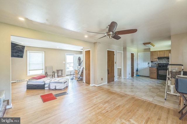 living room with light wood-type flooring, a ceiling fan, baseboards, and recessed lighting