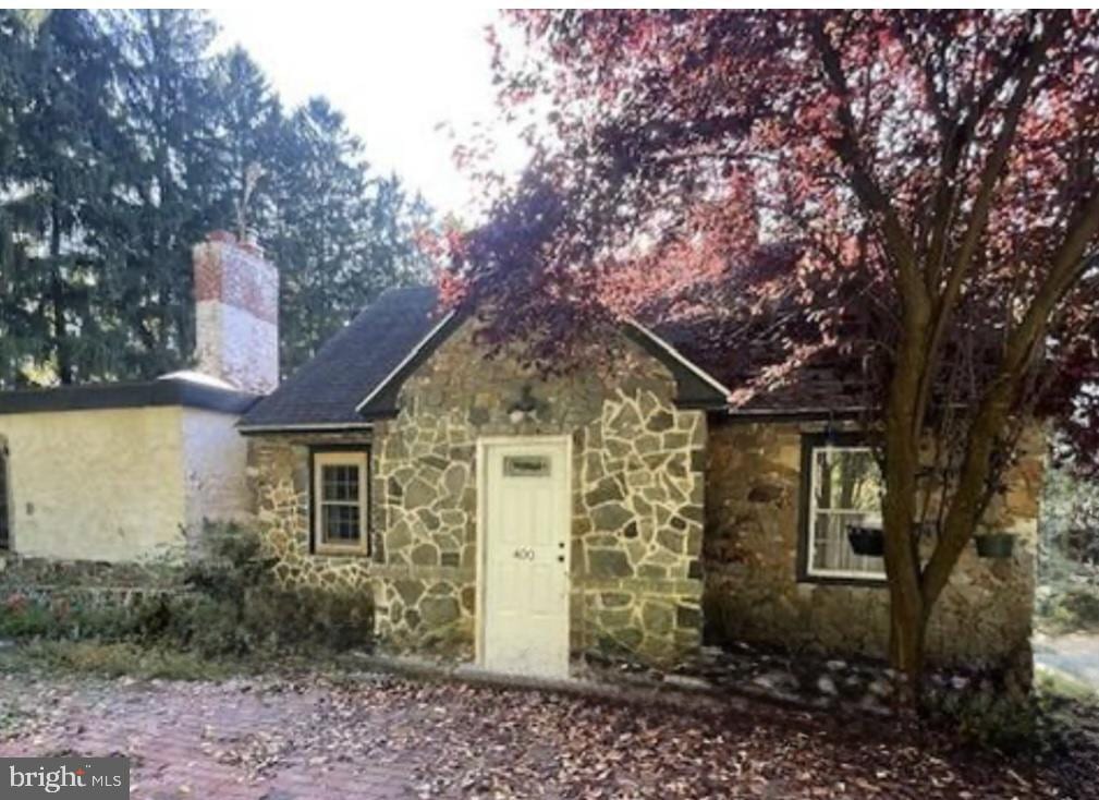 view of front of home featuring a chimney and stone siding