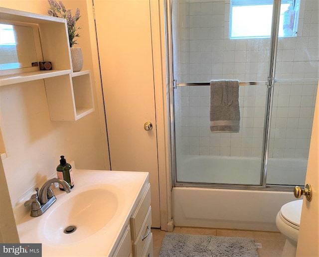 full bath featuring tile patterned floors, vanity, toilet, and bath / shower combo with glass door