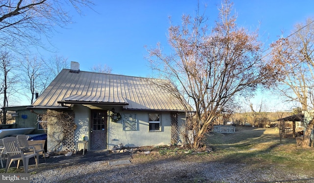 view of front of property with metal roof and a chimney