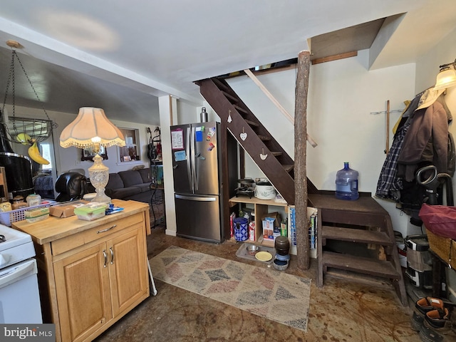 kitchen featuring wood counters, light brown cabinetry, and freestanding refrigerator