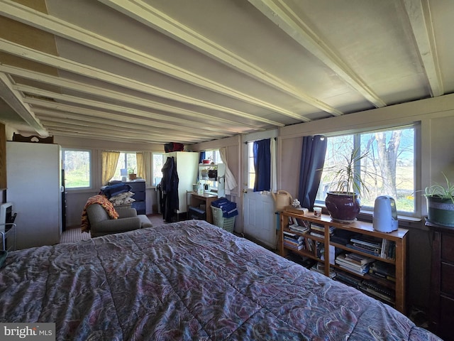 bedroom with freestanding refrigerator and beamed ceiling
