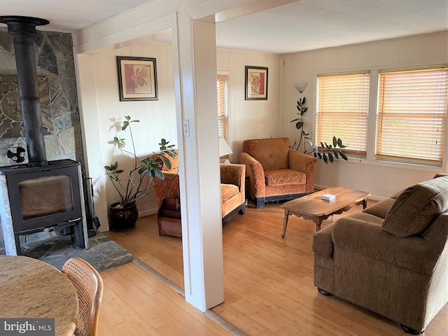 living area with light wood finished floors and a wood stove