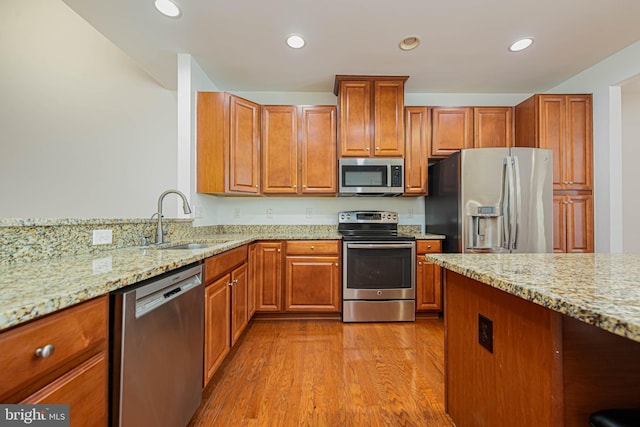 19062 Timbercreek Dr Unit 46, Milton, DE 19968 - kitchen with light stone countertops, wood finished floors, a sink, and stainless steel appliances