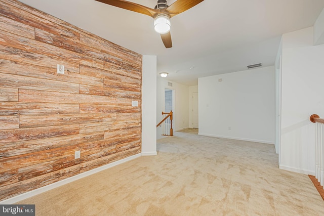 19062 Timbercreek Dr Unit 46, Milton, DE 19968 - spare room featuring visible vents, wooden walls, baseboards, ceiling fan, and light carpet