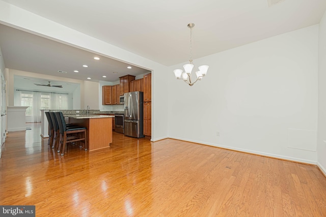 19062 Timbercreek Dr Unit 46, Milton, DE 19968 - kitchen featuring light wood-style floors, brown cabinets, a kitchen breakfast bar, and appliances with stainless steel finishes