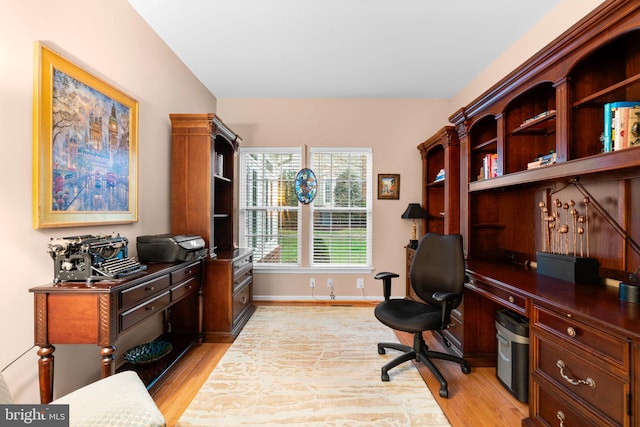 home office with light wood finished floors, baseboards, and lofted ceiling