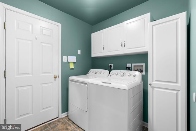 clothes washing area with independent washer and dryer, baseboards, and cabinet space