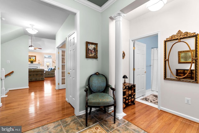 corridor featuring baseboards, ornate columns, and hardwood / wood-style floors