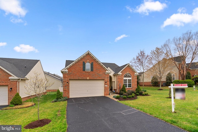 traditional-style house featuring driveway, a front lawn, and brick siding