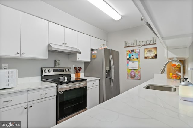 kitchen with white cabinets, stainless steel appliances, a sink, light stone counters, and under cabinet range hood