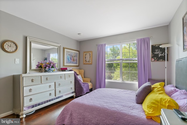 bedroom with baseboards, dark wood-style flooring, and multiple windows