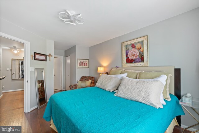 bedroom with baseboards, wood finished floors, and a closet