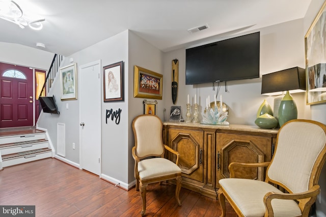 sitting room with hardwood / wood-style floors, visible vents, a bar, and baseboards