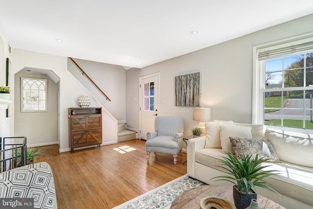 living area featuring light wood-style flooring, recessed lighting, baseboards, and stairway