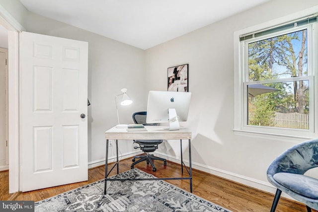 office space with baseboards, plenty of natural light, and wood finished floors