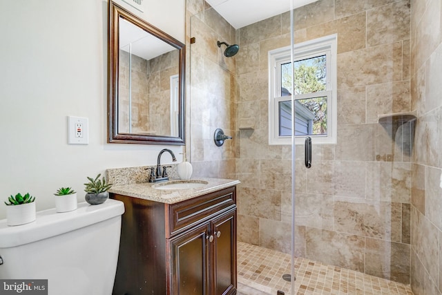 bathroom with a shower stall, vanity, and toilet