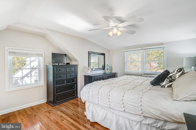 bedroom featuring light wood finished floors, baseboards, a ceiling fan, and lofted ceiling