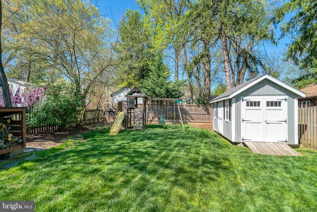view of yard featuring an outdoor structure, a storage shed, a fenced backyard, and a playground