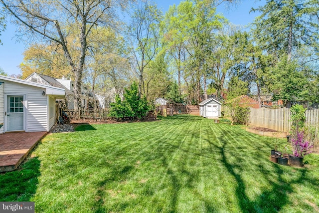 view of yard with an outbuilding, a fenced backyard, and a storage shed
