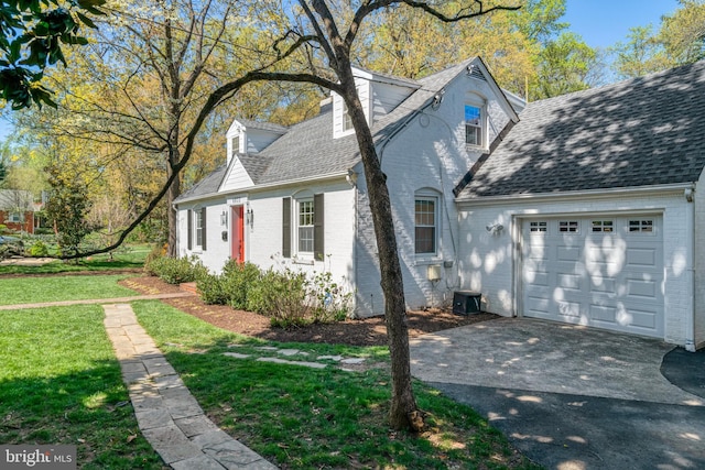 new england style home featuring brick siding, roof with shingles, driveway, and an attached garage