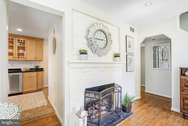 living area featuring visible vents, baseboards, arched walkways, recessed lighting, and light wood-style flooring