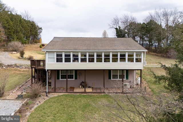 view of front of home with a front yard, a deck, and stairs