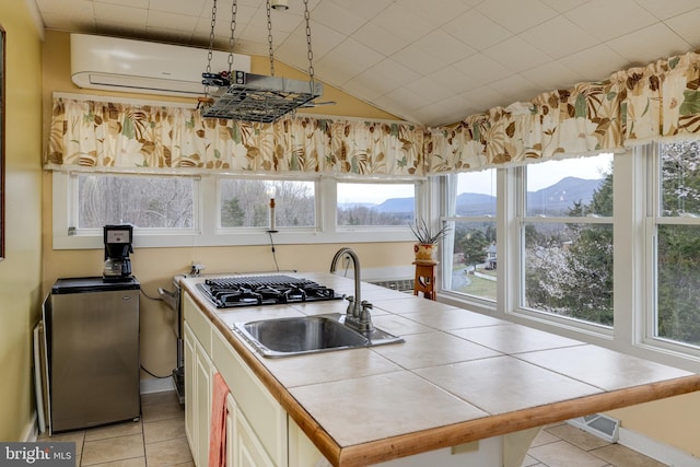 kitchen featuring a wealth of natural light, a sink, and tile counters
