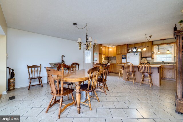 dining space featuring an inviting chandelier, light tile patterned floors, visible vents, and a textured ceiling