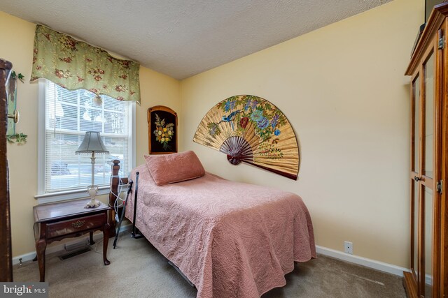 bedroom featuring carpet, baseboards, a textured ceiling, and visible vents