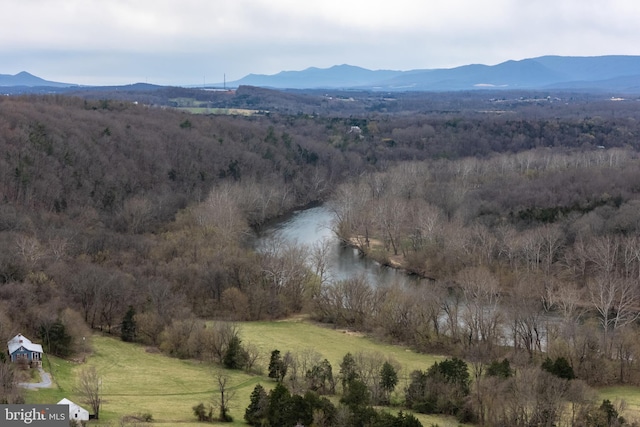 aerial view with a water and mountain view and a wooded view