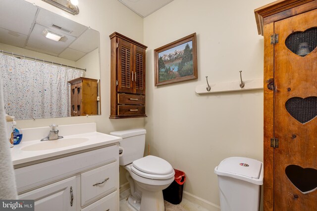 full bath featuring toilet, vanity, a shower with curtain, baseboards, and visible vents