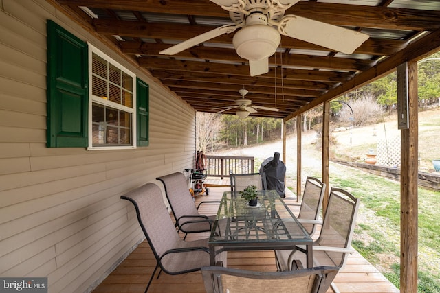 wooden deck featuring a grill, outdoor dining area, and ceiling fan