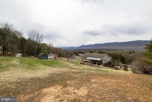 view of yard featuring a storage unit, an outdoor structure, and a mountain view
