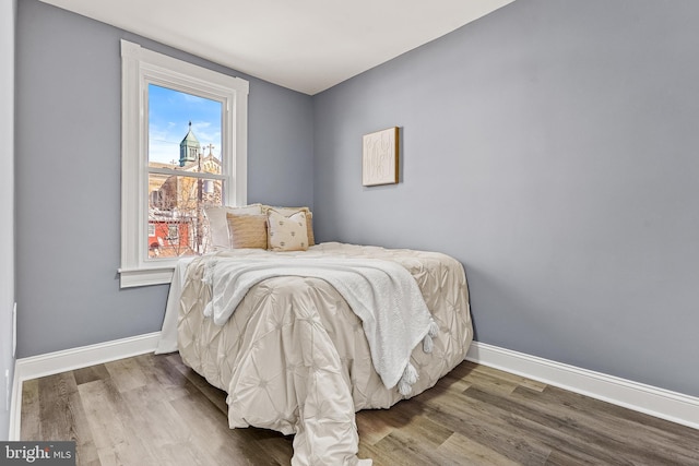 bedroom featuring baseboards and wood finished floors