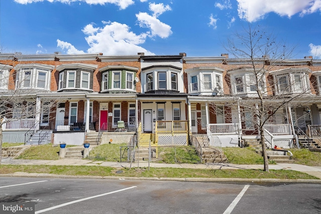 multi unit property featuring uncovered parking and a porch