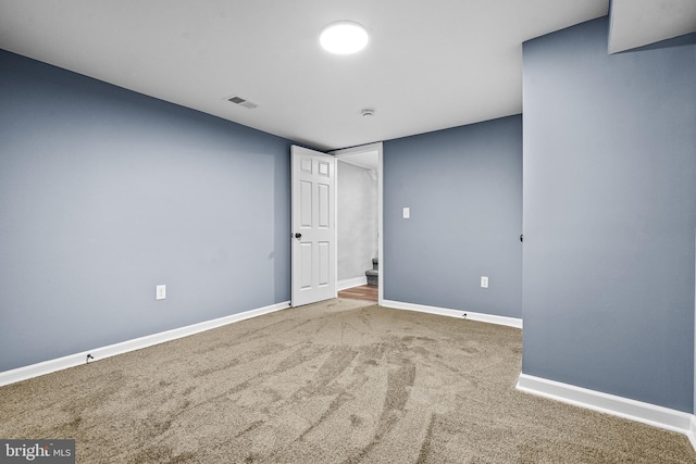 carpeted empty room featuring baseboards and visible vents