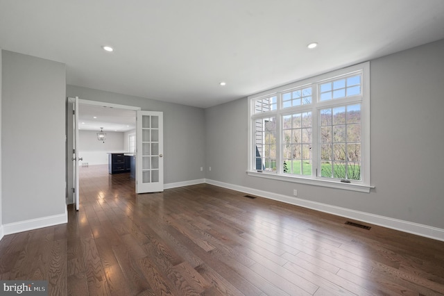 unfurnished living room with dark wood-style floors, baseboards, french doors, and visible vents