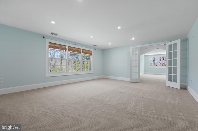 empty room with baseboards, visible vents, recessed lighting, and light colored carpet
