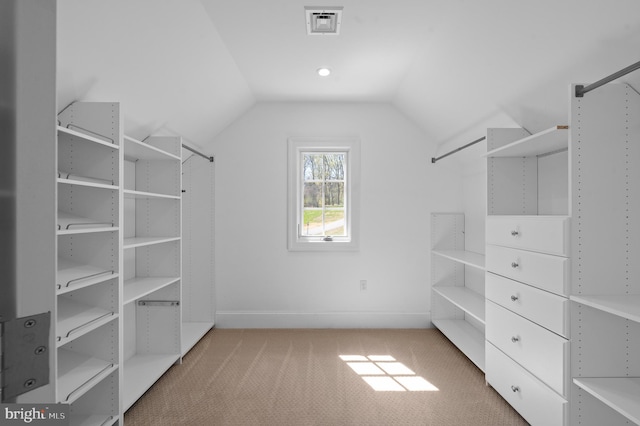 walk in closet with vaulted ceiling, visible vents, and carpet floors