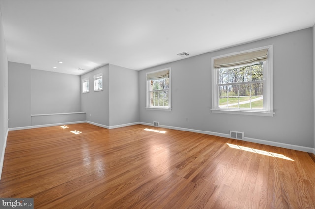 unfurnished room with baseboards, light wood-style flooring, and visible vents