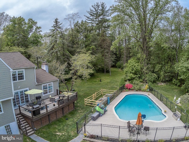 view of pool with a yard, fence, a deck, and a fenced in pool