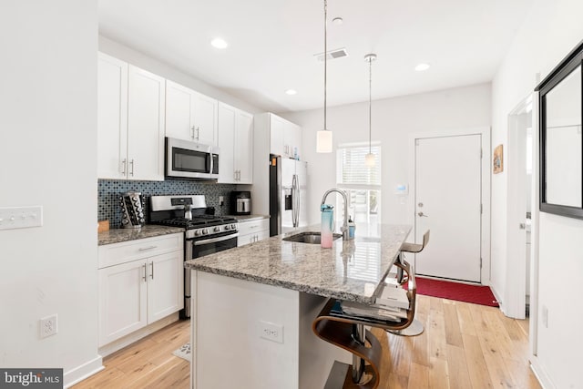 1649 N Randolph St, Philadelphia, PA 19122 - kitchen featuring stainless steel appliances, a sink, light wood-style flooring, a center island with sink, and white cabinets