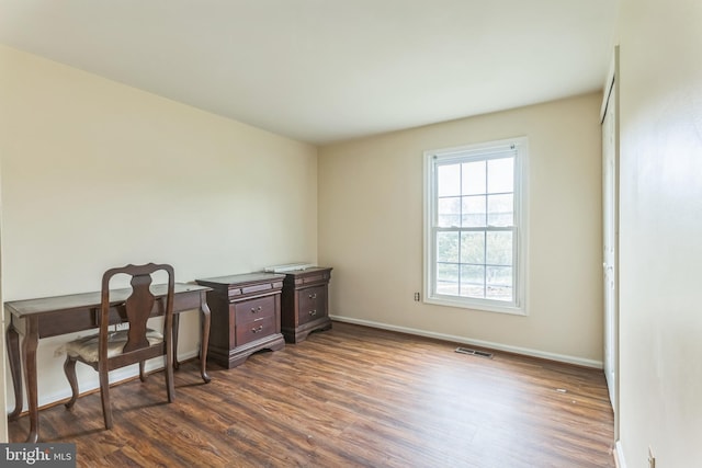 office space featuring baseboards, dark wood-style floors, and visible vents