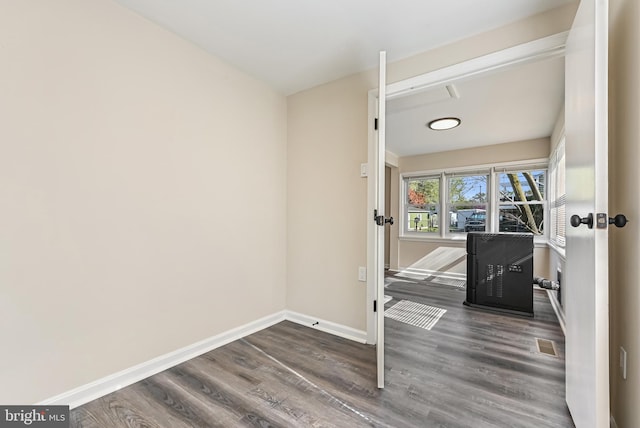 empty room with visible vents, baseboards, and wood finished floors