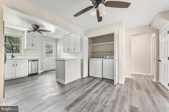 laundry room with light wood finished floors, laundry area, a ceiling fan, baseboards, and separate washer and dryer